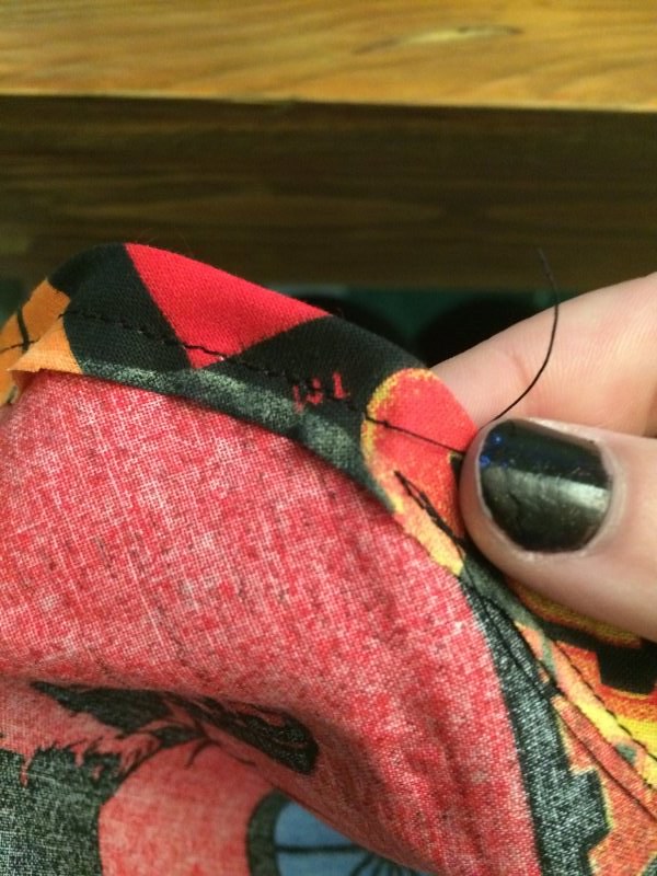 Fold over the edge and stitch! Leave a small opening so you can thread the string back through.